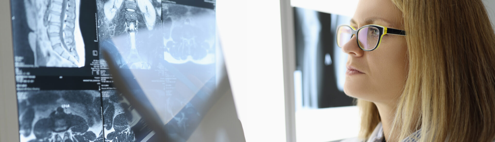 Female doctor examines an X-ray in medical office.